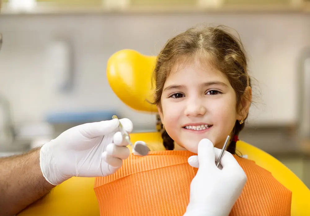 Little girl is having her teeth checked by dentist